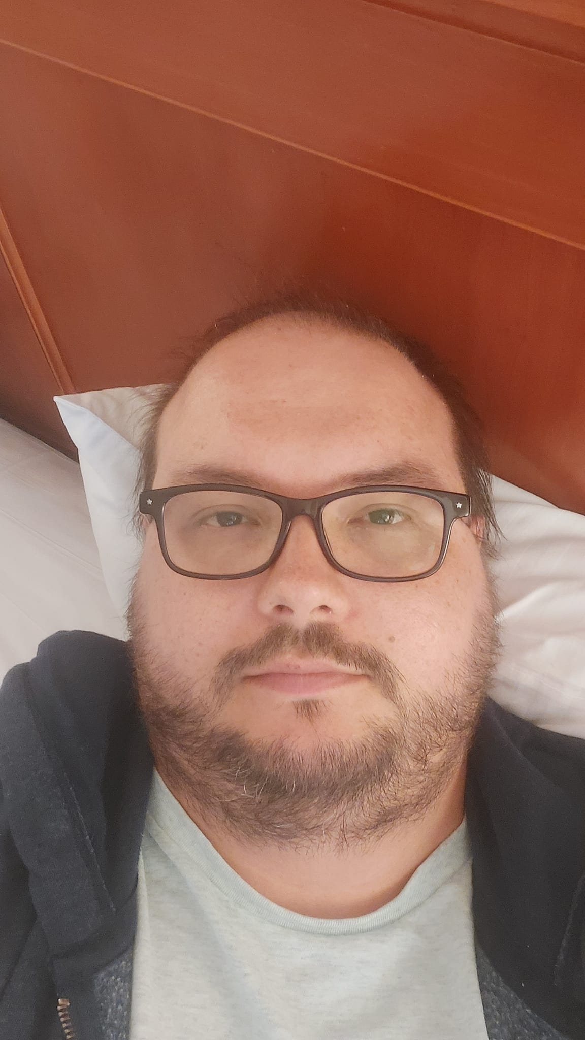 A man looks exhausted, lying in a hotel bed